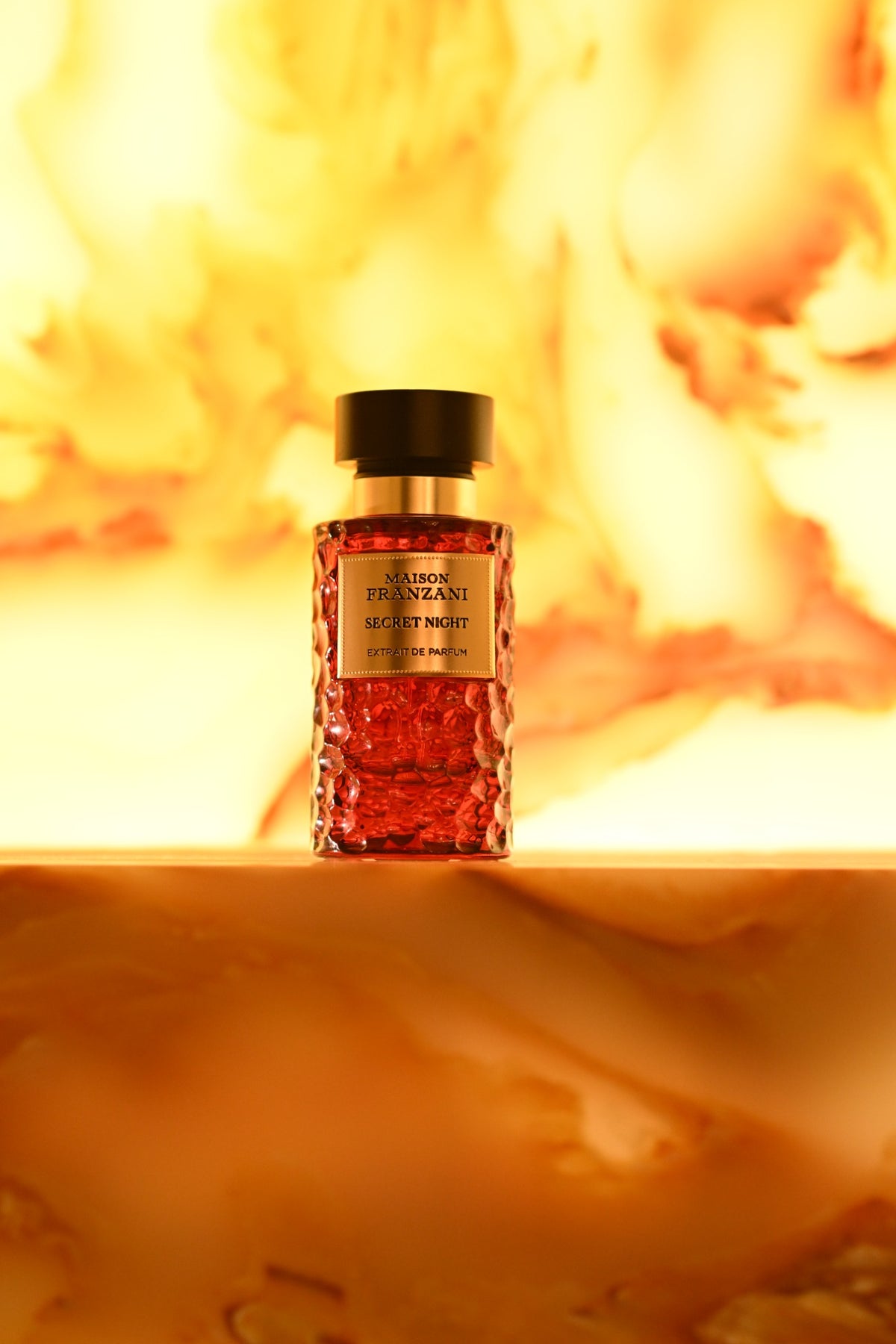 MAISON FRANZANI FIRE Secret Night Extrait de Parfum – roter Flakon vor leuchtenden Flammen